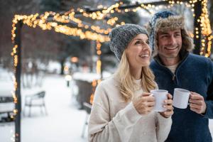 a man and a woman holding a cup of coffee at Romantik Hotel & Restaurant Stafler in Vipiteno