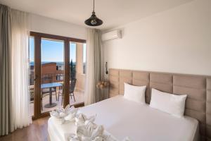 a bedroom with a white bed and a balcony at Villa Lazy Hill in Budva