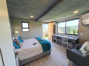 a bedroom with a bed and a desk and a window at Riverview Guesthouse East London in East London