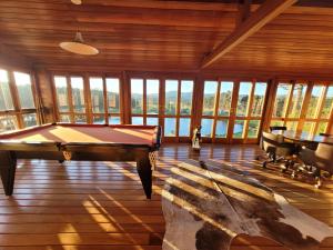 a pool table in a room with windows at Hotel Fazenda Boutique Terra do Gelo in Bom Jardim da Serra