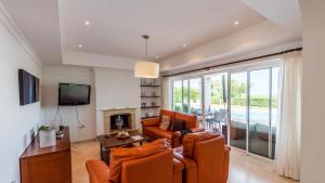 uma sala de estar com duas cadeiras laranja e uma televisão em Villa Grazalema 2 - Villa 39 Arcos de la Frontera by Ruralidays em Arcos de la Frontera