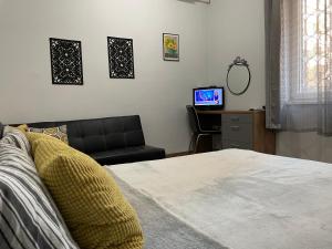 - une chambre avec un lit et un bureau avec une télévision dans l'établissement The Central Post Apartments, à Sofia