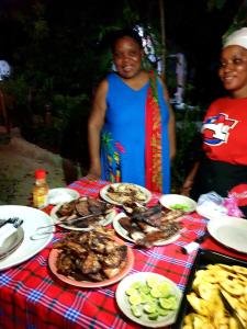 a table with plates of food on it at Fontaine Garden Village in Bwejuu