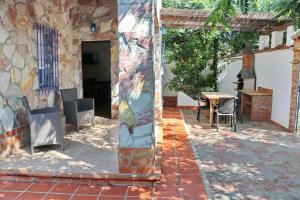 a patio with a table and a stone wall at Bungalow La Roa II in Conil de la Frontera +22 photos
