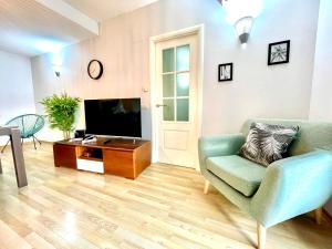 a living room with a couch and a tv at SeaHomes Vacations, FENALS BEACH&CHIC, pk, top apartment full equipped in Lloret de Mar
