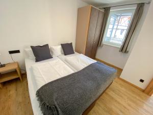 een wit bed in een kamer met een raam bij Suiten Am Schloss in Kitzbühel