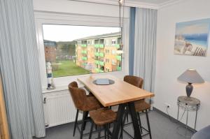 een eetkamer met een tafel en een groot raam bij Appartement-254 in Westerland