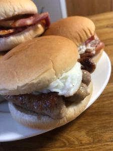 deux hamburgers avec saucisse et œuf sur une assiette dans l'établissement Ardmorn Holiday Accommodation, à Dunvegan