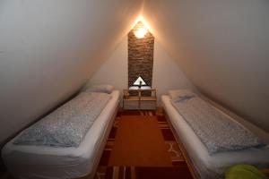 2 łóżka w pokoju na poddaszu z ceglaną ścianą w obiekcie Apartmány Sněženka w mieście Deštné v Orlických horách