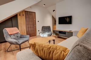 - un salon avec un canapé, deux chaises et une télévision dans l'établissement Apartmani Studio Proforma, à Kolašin