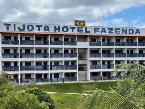 a hotel with a sign on the top of it at Tijota Hotel Fazenda in Ipatinga
