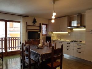 une cuisine avec une table et des chaises et une cuisine avec une table dans l'établissement Apartment La Gleisa 3, à Sestrières 9 autres photos