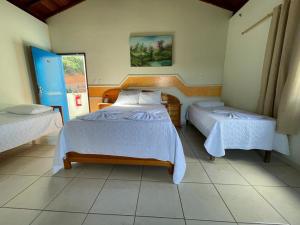 a bedroom with two beds in a room at Tijota Hotel Fazenda in Ipatinga