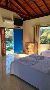 a bedroom with a blue bed and a dresser and window at Tijota Hotel Fazenda in Ipatinga