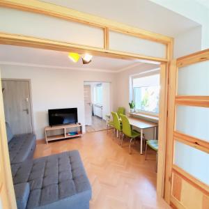 a living room with a table and green chairs at Dla Przyjaciół - Apartamenty nad morzem in Mosty +46 photos