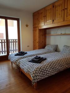 two beds in a bedroom with wooden floors at Apartment La Gleisa 3 in Sestriere