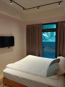大漢村的住宿－邦迪民宿，一间卧室设有一张床和一个大窗户