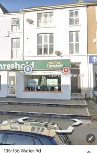 a white building with a sign in front of it at The Old Office - 1 Bed Studio in Swansea