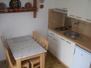una piccola cucina con tavolo e lavandino di Apartments Dunoti a Krk
