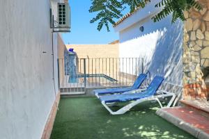 two blue chairs sitting on the grass in a backyard at Chalet La Roa III in Conil de la Frontera