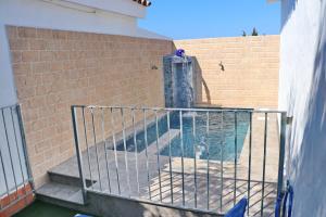 una piscina con una fuente en una pared de ladrillo en Chalet La Roa III, en Conil de la Frontera