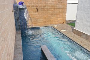 a swimming pool with a waterfall in a building at Chalet La Roa III in Conil de la Frontera