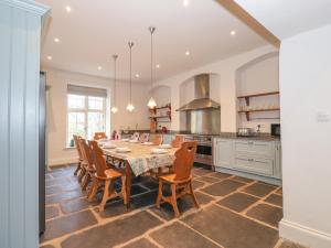 uma sala de jantar com uma mesa e cadeiras numa cozinha em Thwaite House em Coniston