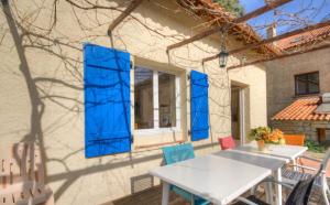 un tavolo e sedie su un patio con persiane blu di Gîtes Carbuccia en Corse avec piscine chauffée a Carbuccia Altre 61 foto