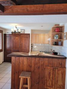 eine Küche mit Holzschränken und einem Holzhocker in der Unterkunft Chalet LE TRIOLET in Chamonix-Mont-Blanc