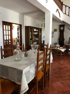 uma sala de jantar com uma mesa com uma toalha de mesa branca em vivenda descollaz em Falcoeiras