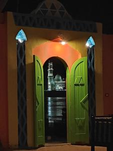 una entrada a un edificio con puertas verdes en Maghrabi's Guest house en Asuán