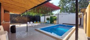 una piscina en medio de una casa en CABAÑA LAS MARIAS, Climatizada, Piscina y BBQ, en Santa Marta