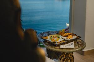 a table with a plate of food on it with the ocean at Espuma Hotel - Adults Only in Zihuatanejo