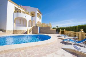 a villa with a swimming pool in front of a house at Villa Cactus - PlusHolidays in Calpe
