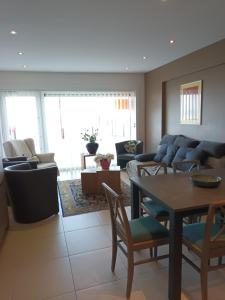 a living room with a couch and a table and chairs at Appartement Borealis in Blankenberge