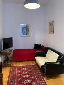 a living room with a couch and a red blanket at Villa Pazelt Top3 in Bad Vöslau