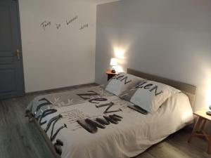 a bedroom with a bed with writing on the wall at Sur la Colline in Sousceyrac
