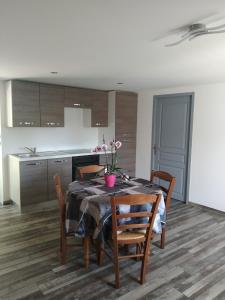 a kitchen and dining room with a table and chairs at Sur la Colline in Sousceyrac