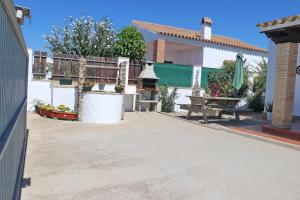 a patio of a house with a bench and a table at Chalet Chaparrillo in Conil de la Frontera