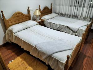 two beds with pillows and pillows in a room at Baires Portomarin in Portomarin