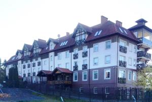 a large white building with a red roof at Apartamenty Żeglarskie Vęgoria 4 in Węgorzewo