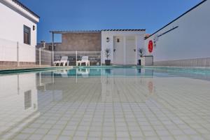 una piscina con 2 sillas y una cancha de baloncesto en Chalet moderno con pisicina, en Conil de la Frontera