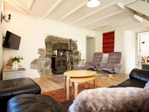a living room with a couch and a stone fireplace at Pass the Keys South Lodge Coastal Cottage in Dyffryn