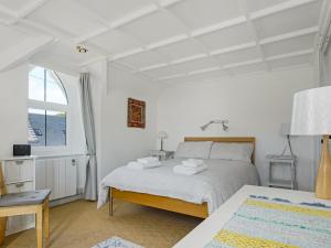 - une chambre blanche avec un lit et une fenêtre dans l'établissement Pass the Keys South Lodge Coastal Cottage, à Dyffryn