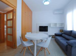 een woonkamer met een tafel en stoelen en een bank bij La Platgeta · La Platgeta · Ideal family apartment, with private terrace in Vilassar de Mar