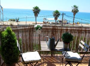 a patio with a table and chairs and the beach at Panier en Osier · Panier en Osier · Charming apartment w/private terrace 2min from sea in Vilassar de Mar