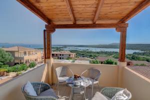 patio con mesa y sillas en el balcón en Baia de Bahas Residence, en Golfo Aranci