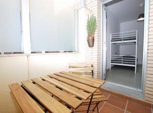 drewniany stół i krzesła w pokoju z oknem w obiekcie Petit niu · Petit niu · Apartamento AC - 3 min de la playa w mieście Vilassar de Mar
