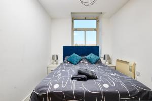 ein Schlafzimmer mit einem großen Bett mit einer blauen Decke in der Unterkunft Executive Apartment in Dewsbury- Sleeps 6 in Leeds