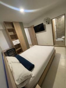 1 dormitorio con 1 cama con escalera y TV en HOTEL MEDELLIN CENTRAL, en Medellín